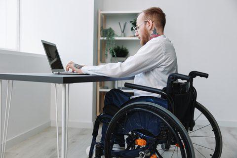 Man in a wheelchair at work stock image