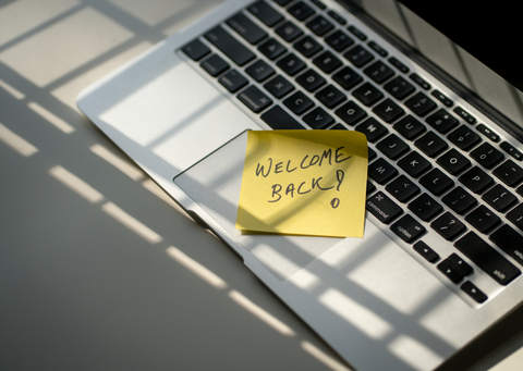 Welcome back post-it note on a laptop
